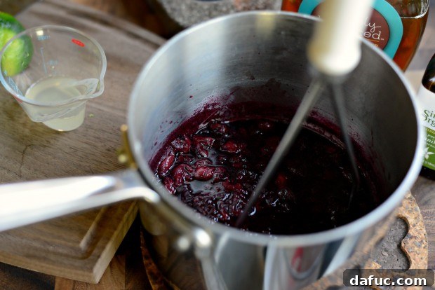 Cooked cherries, softened and juicy, in the saucepan after simmering.