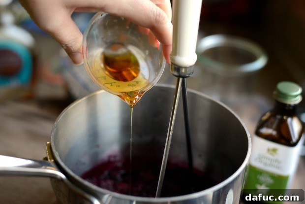 A tablespoon of freshly squeezed lime juice being poured into the mashed cherries.