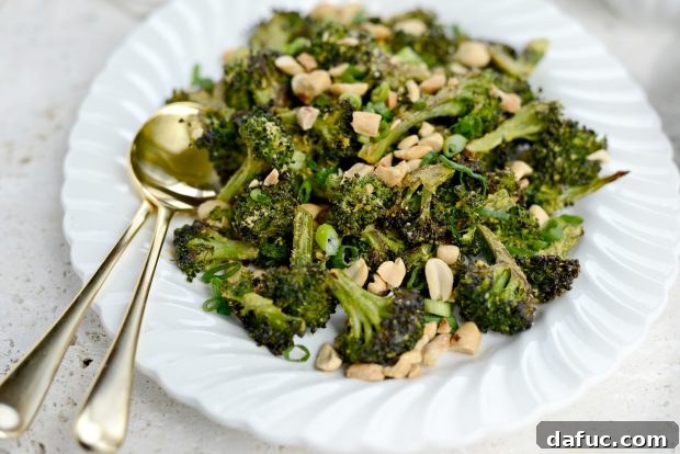 Savory Roasted Broccoli with Toasted Peanuts 15 Roasted broccoli with seasonings being tossed to combine all ingredients.
