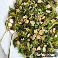 Roasted Broccoli with Peanuts on a white plate with a side of salmon.