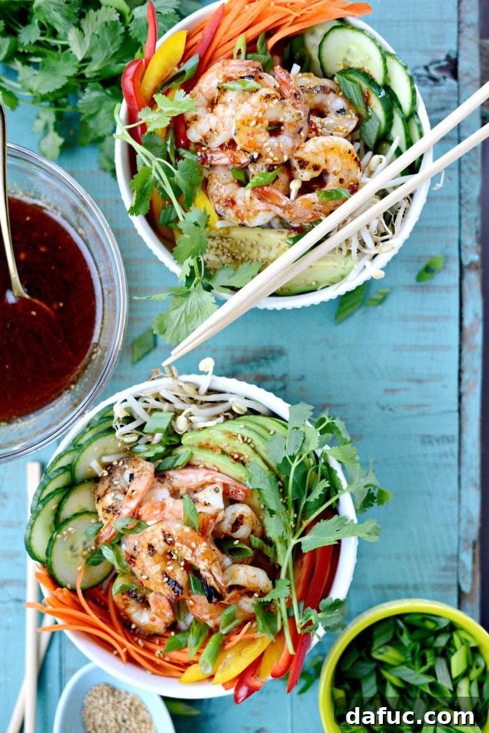 Vibrant Grilled Shrimp Spring Roll Noodle Bowls 2 Colorful Grilled Shrimp Spring Roll Noodle Bowls with fresh vegetables and a savory dressing.