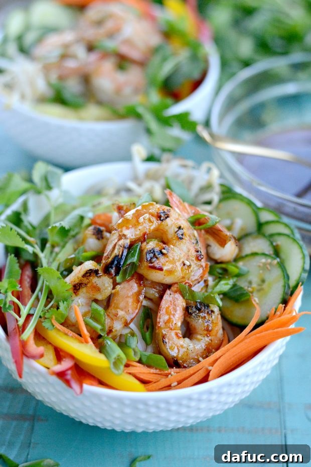 Vibrant Grilled Shrimp Spring Roll Noodle Bowls 13 Finished grilled shrimp spring roll noodle bowl, garnished with green onions and sesame seeds.