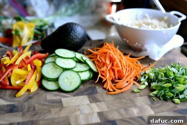 Vibrant Grilled Shrimp Spring Roll Noodle Bowls 4 Freshly chopped vegetables, including bell peppers and cucumbers, ready for assembly.