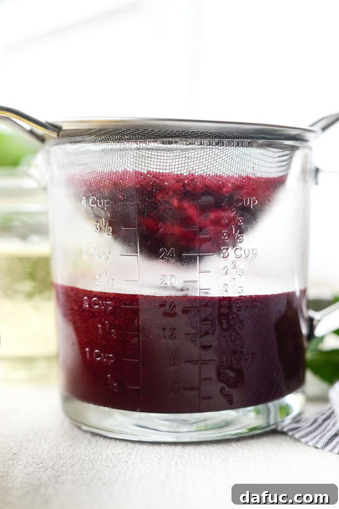 Straining the blueberry lemon puree through a mesh strainer