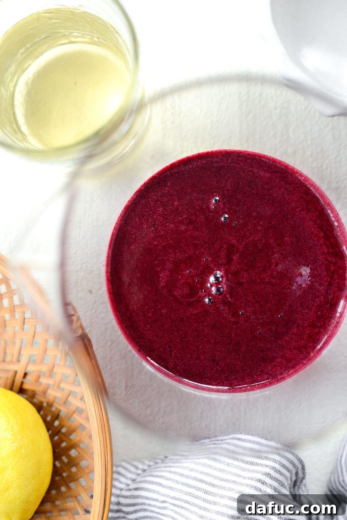 Pouring the strained blueberry lemon mixture into a pitcher