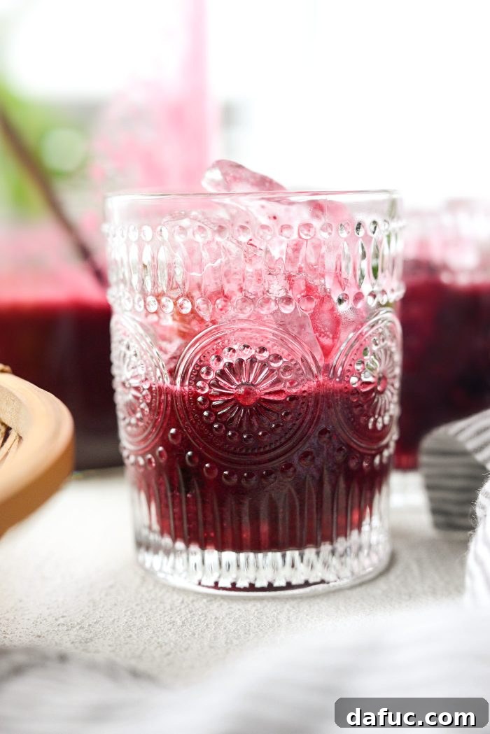Filling glasses halfway with blueberry wine mixture