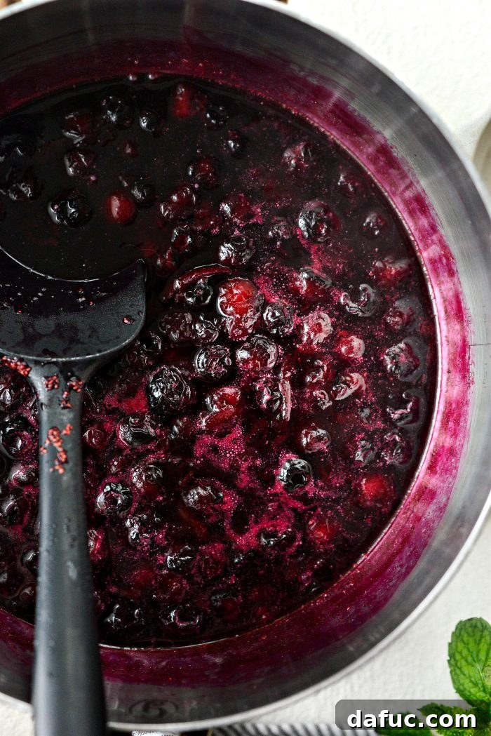 Blueberries simmering with lemon juice and zest in a saucepan