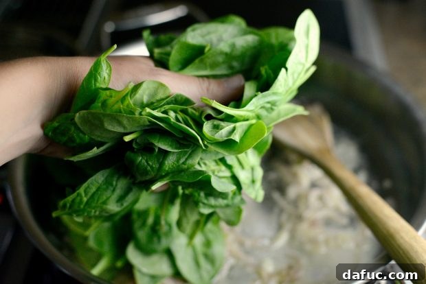 Spinach, garlic, and shallot mixture in food processor with almonds