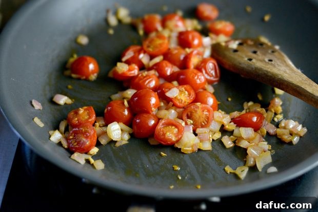 Grilled Red Snapper with a Vibrant Fiesta Olive Medley 10 Cherry tomatoes cooking in the skillet, their skins beginning to wrinkle and juices releasing.