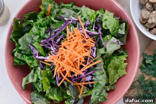 Freshly chopped romaine lettuce, red leaf lettuce, carrots, and cabbage for the salad