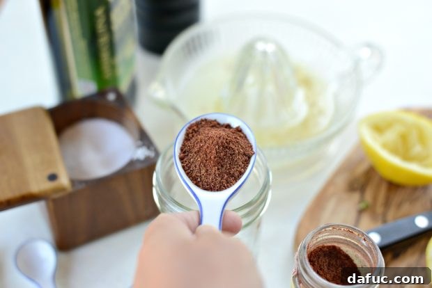 Adding ground sumac to a jar for lemon sumac dressing