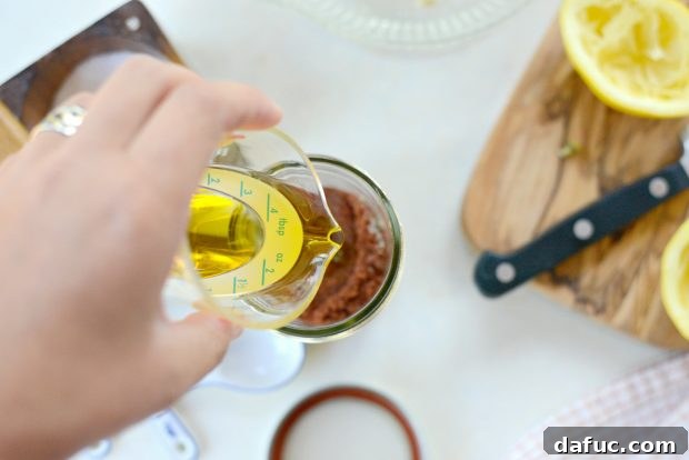 Adding olive oil to the lemon sumac dressing mixture