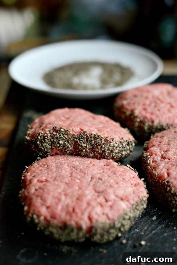 Raw Burger Patties with Hand-Cracked Peppercorn Edges Ready for Grilling
