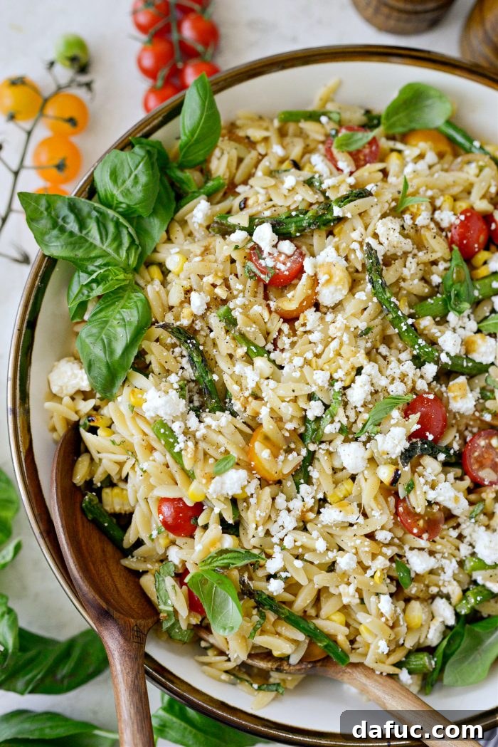 Vibrant Grilled Corn Orzo Salad 2 Vibrant Asparagus Tomato and Grilled Corn Orzo Pasta Salad in a large bowl, showcasing its fresh ingredients and inviting colors.