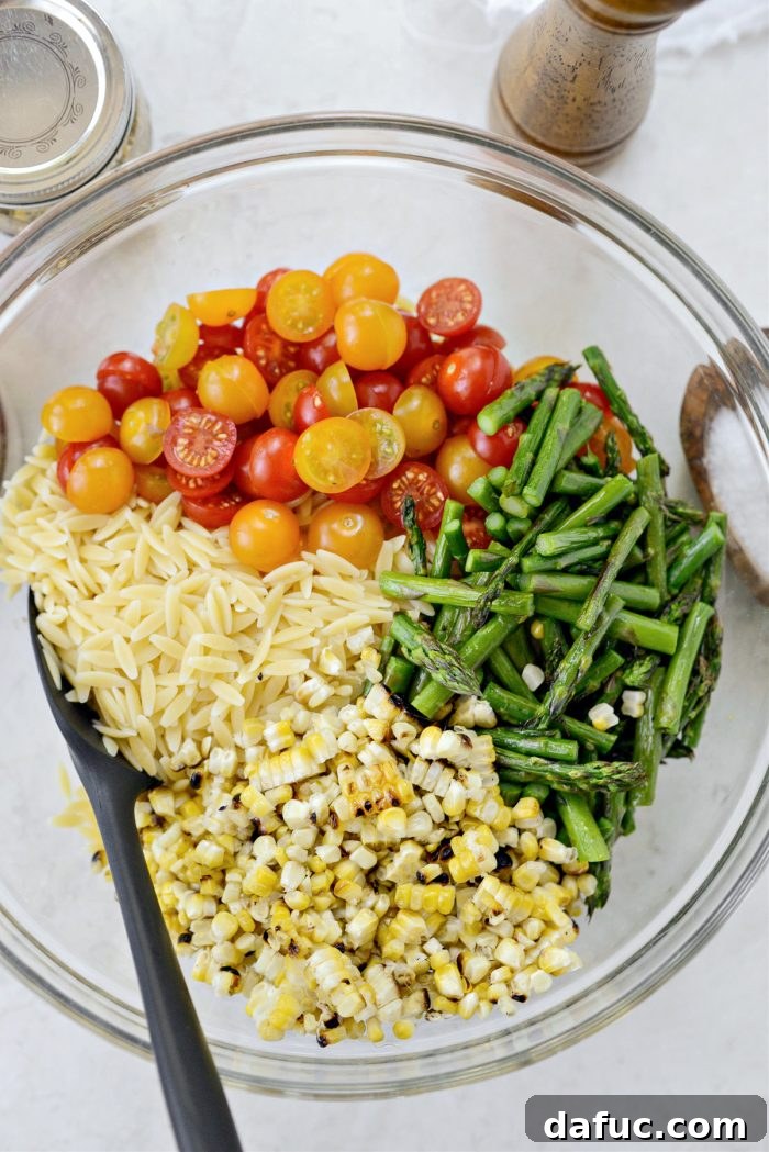 Vibrant Grilled Corn Orzo Salad 12 All the prepared salad components – cooked orzo, grilled corn, roasted asparagus, and halved cherry tomatoes – gathered in a large mixing bowl.