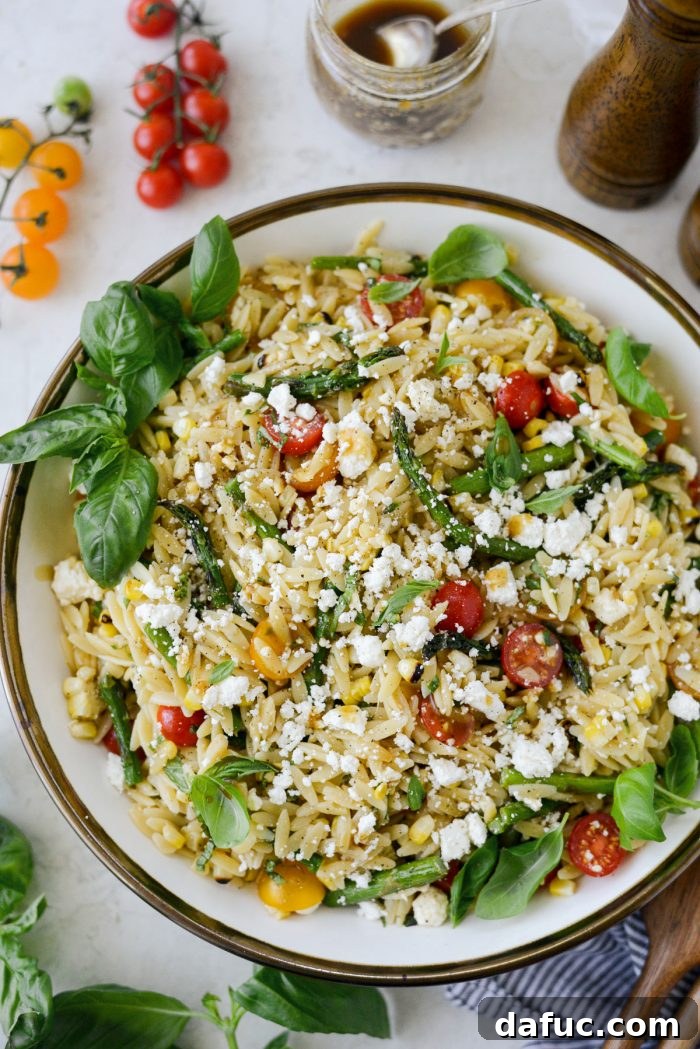 Vibrant Grilled Corn Orzo Salad 17 A beautifully presented serving bowl filled with the Asparagus Tomato and Grilled Corn Orzo Pasta Salad, garnished with fresh basil.
