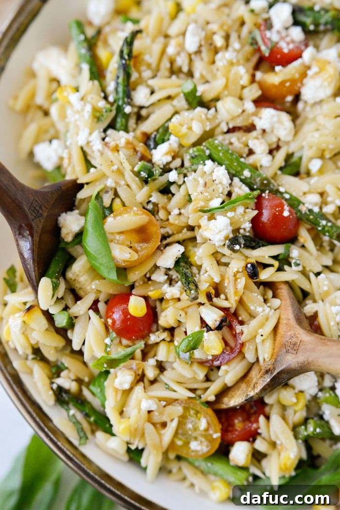 Vibrant Grilled Corn Orzo Salad 18 A close-up of a serving of Asparagus Tomato and Grilled Corn Orzo Pasta Salad, showing the individual ingredients and appealing texture.