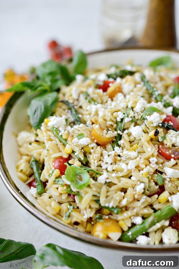 Vibrant Grilled Corn Orzo Salad 3 Close-up of the Asparagus Tomato and Grilled Corn Orzo Pasta Salad, highlighting the texture of the orzo, corn kernels, and fresh basil.