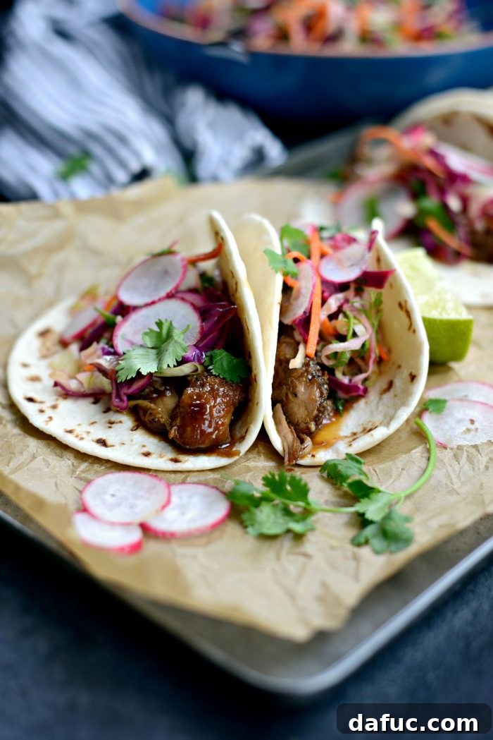 Korean Braised Pork Tacos 9 An array of delicious Braised Korean Pork Tacos with fresh toppings, ready to be served.