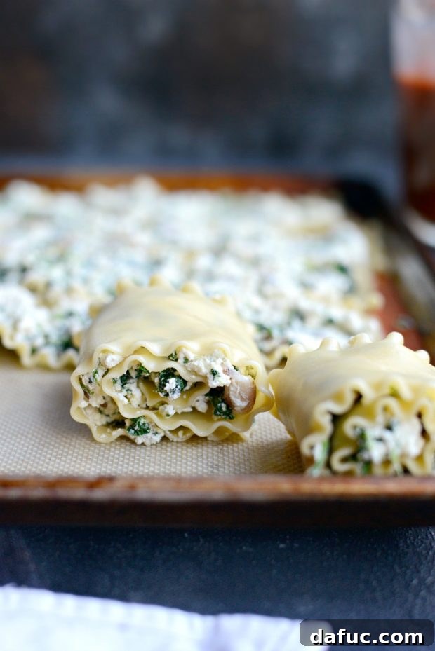 Lasagna noodles filled with ricotta and rolled up, placed in a baking dish