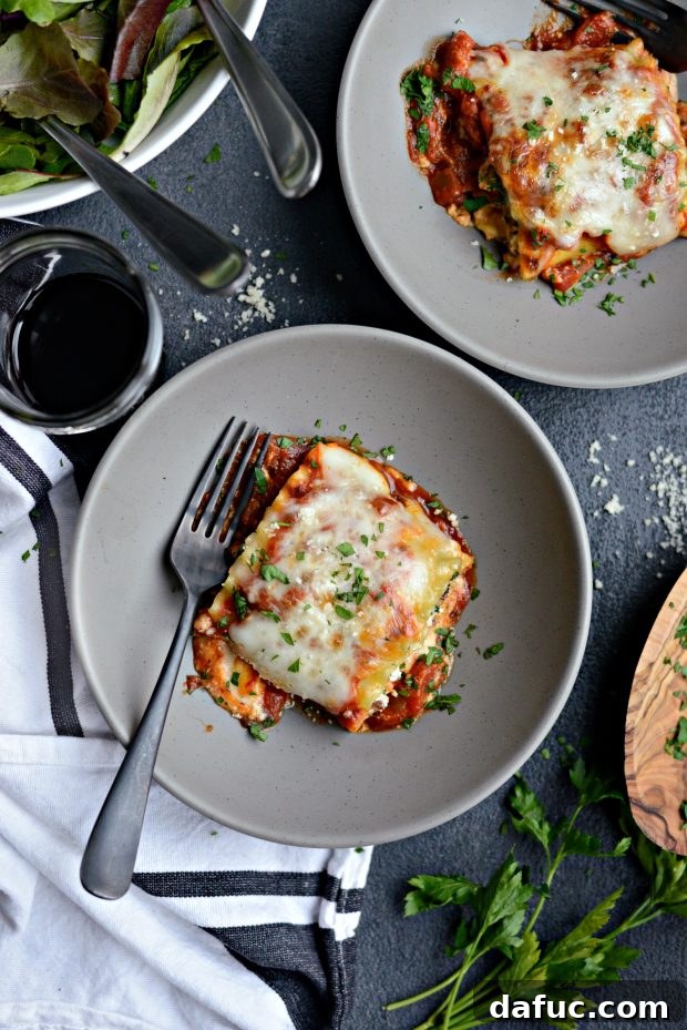 Stacked lasagna roll-ups in a pan, showcasing their layers and delicious appearance