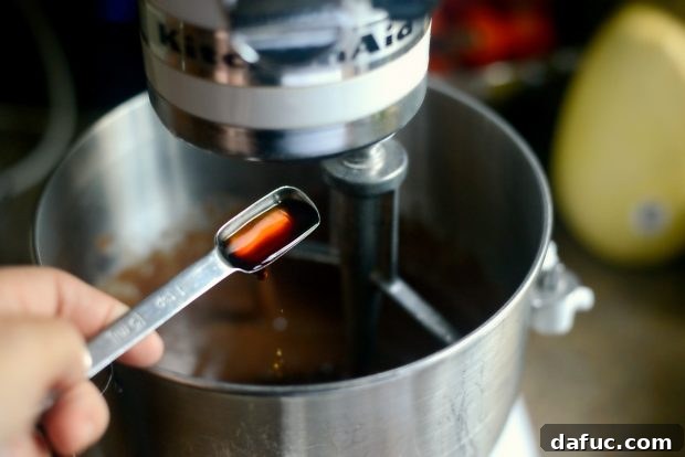 Adding vanilla extract to chocolate cake batter in a stand mixer