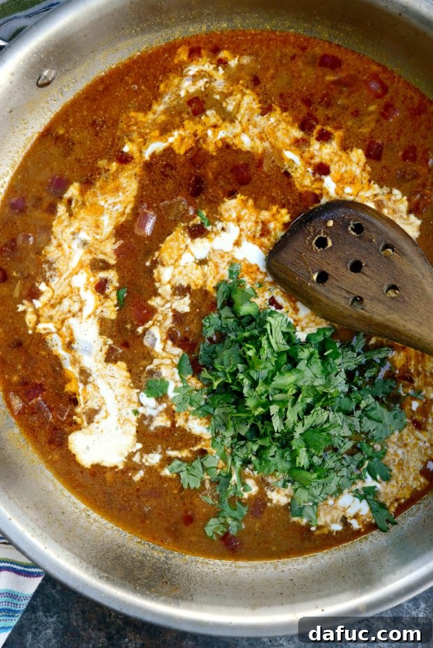 Sauce with cream and cilantro - A creamy white sauce being prepared in a skillet with fresh cilantro.