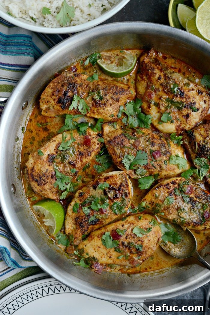 Easy One Skillet Creamy Cilantro Lime Chicken - A close-up shot of the creamy chicken in a skillet, garnished with fresh herbs.