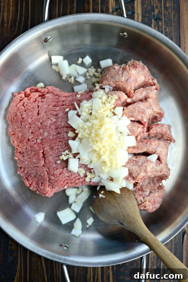 Cooking ground beef, Italian sausage, onions, and garlic in a skillet