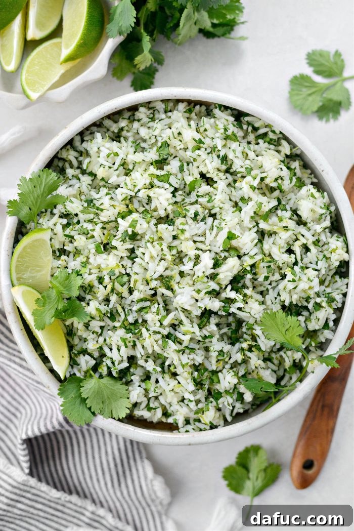 A bowl of freshly made Cilantro Lime Rice, garnished with a lime wedge