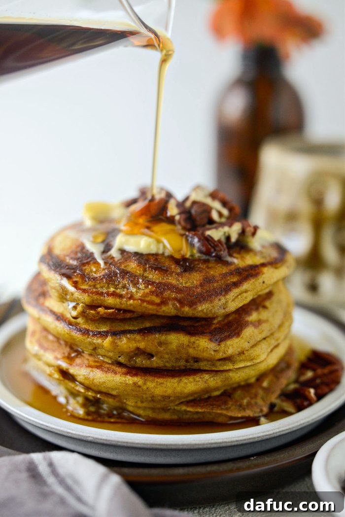 Spiced Brown Butter Pumpkin Pancakes 14 A towering stack of freshly made Brown Butter Pumpkin Pancakes, golden and fluffy, inviting a delicious breakfast.