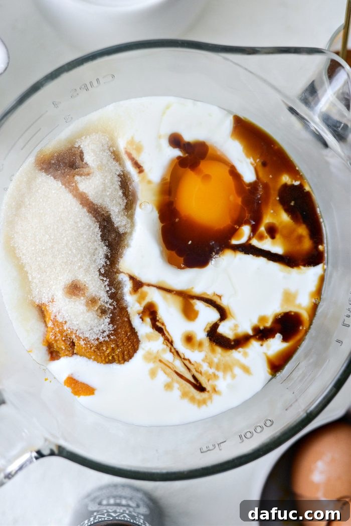 Spiced Brown Butter Pumpkin Pancakes 7 A separate bowl holding all the wet ingredients for the pumpkin pancakes, including pumpkin puree and buttermilk.