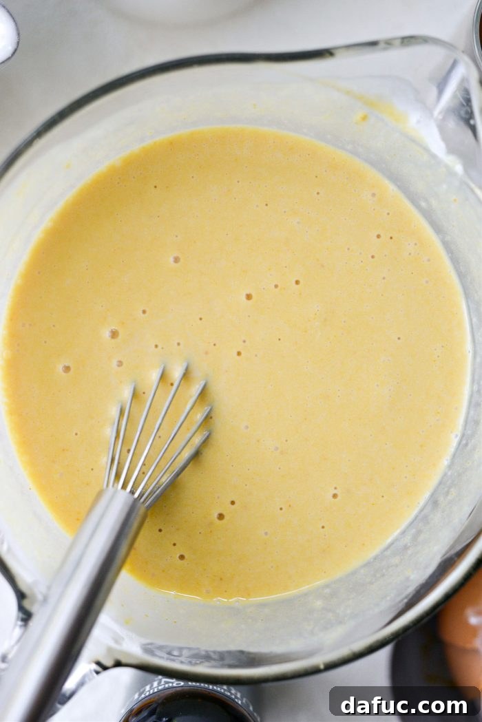Spiced Brown Butter Pumpkin Pancakes 8 The wet ingredients, now thoroughly whisked, showcasing a smooth and consistent mixture.