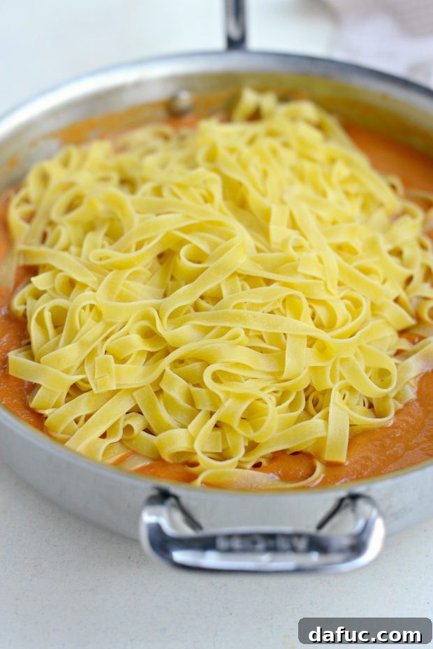 Velvety Roasted Red Pepper Pasta 8 Adding Cooked Fettuccine Pasta to Red Pepper Sauce