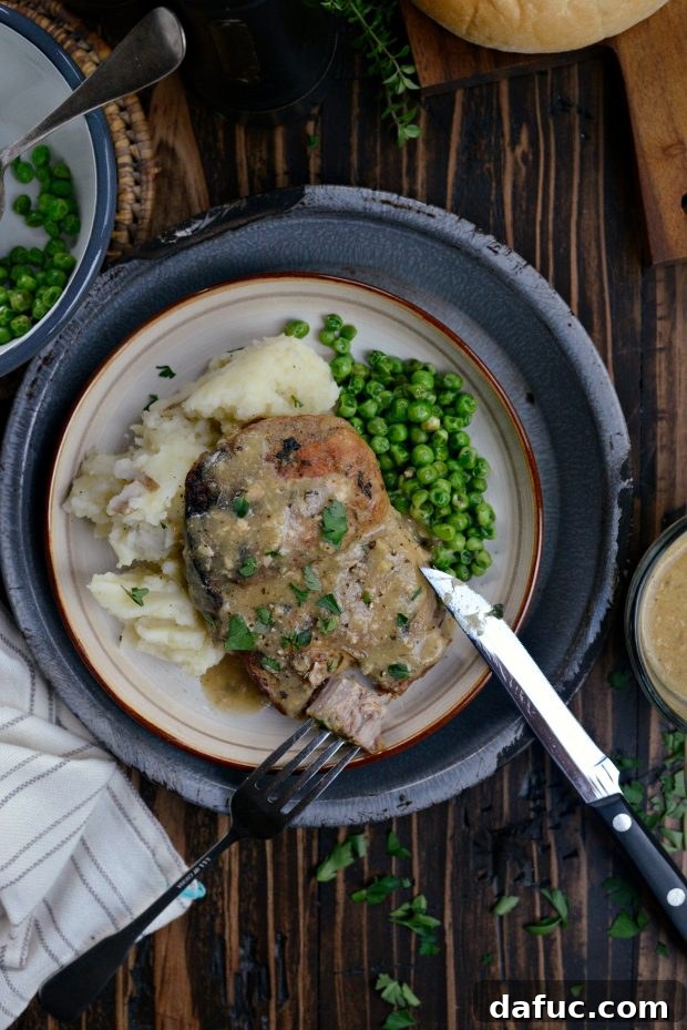 A forkful of tender slow cooker pork chop with gravy