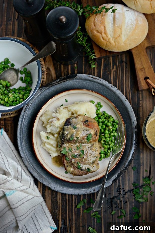 Beautifully plated slow cooker pork chops with herb gravy and sides
