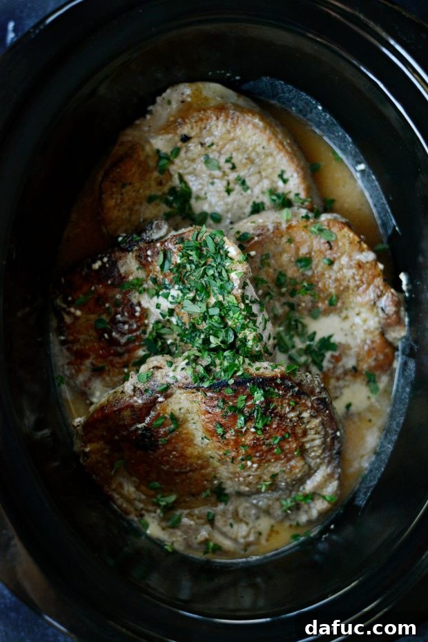 Adding fresh herbs to pork chops and gravy in the slow cooker
