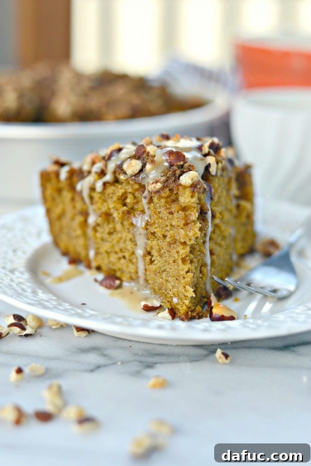 Close-up of a full pumpkin coffee cake with a generous drizzle of maple glaze