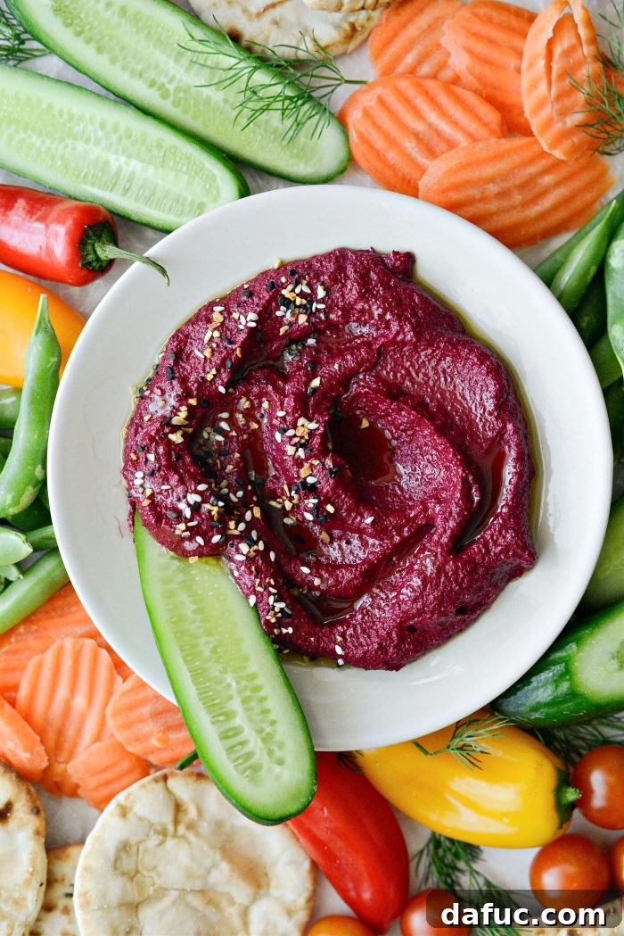 Vibrant Roasted Beet Hummus 2 A bowl of vibrant Roasted Beet Hummus, garnished with fresh herbs and olive oil