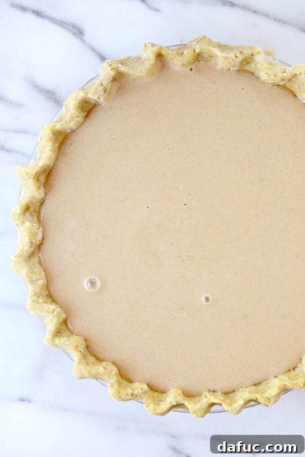 Exotic Chai Pumpkin Pie 8 Pouring Chai Pumpkin Pie filling into a pie crust