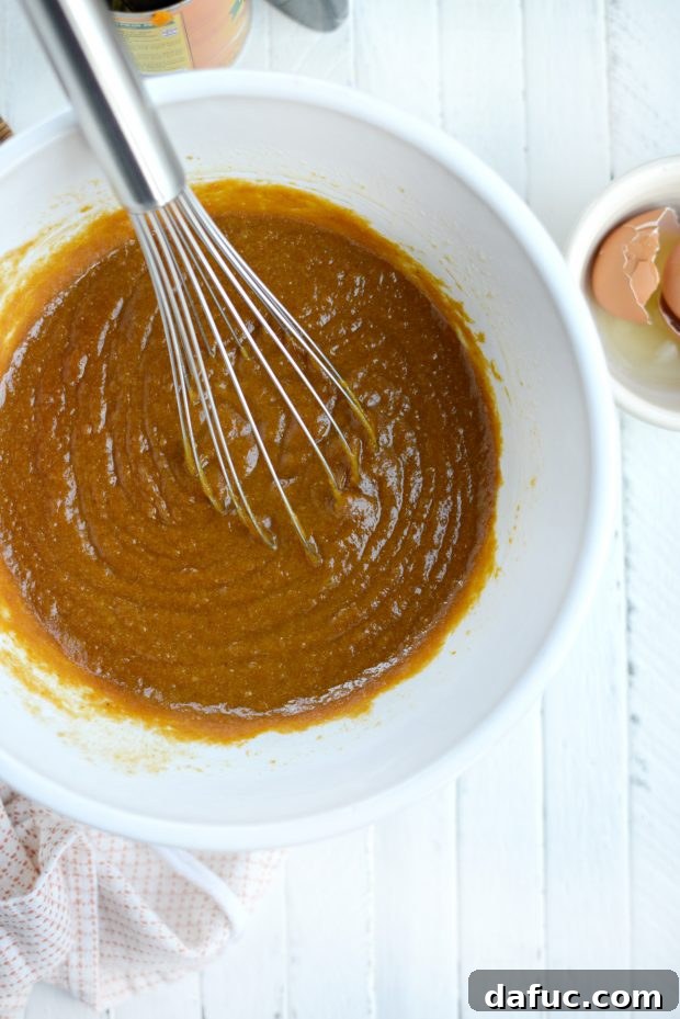 Mixing wet ingredients for pumpkin doughnut batter