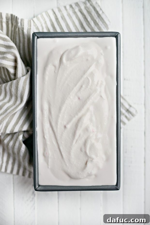 Folding crushed candy canes into peppermint ice cream