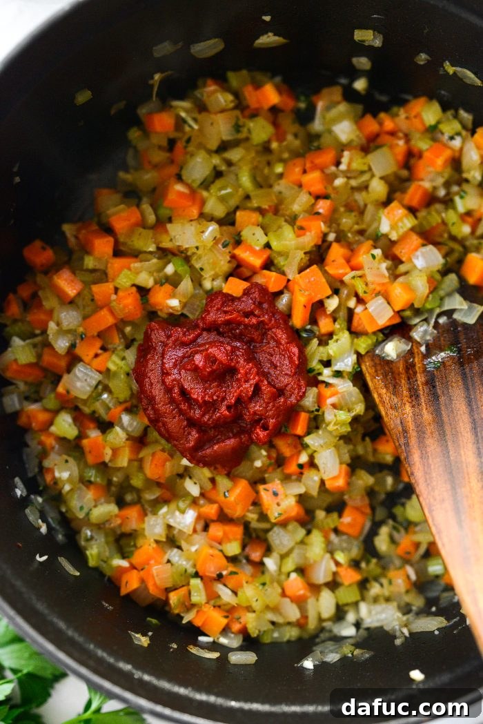 Smoky Bean and Bacon Delight 12 Adding concentrated tomato paste to the soup base, a crucial step for deepening the umami flavor and color.