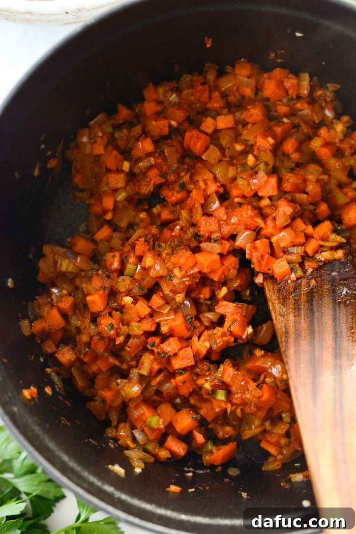 Smoky Bean and Bacon Delight 13 Stirring the cooked tomato paste into the vegetables, preparing for the liquid ingredients.