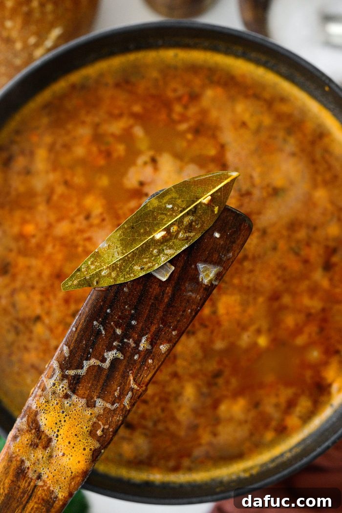 Smoky Bean and Bacon Delight 18 Removing a bay leaf from the simmering soup, a final step before seasoning.