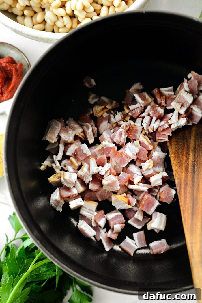 Smoky Bean and Bacon Delight 5 Diced center-cut bacon being added to a cold Dutch oven, illustrating the first step in creating a flavorful soup base.