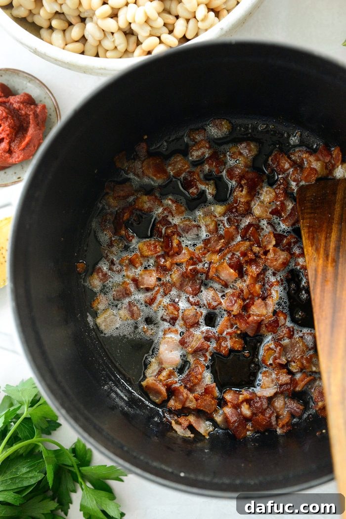 Smoky Bean and Bacon Delight 6 Crispy bacon sizzling in a Dutch oven, highlighting the texture and color achieved through proper cooking.