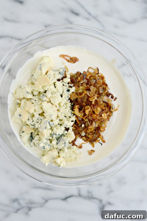 Sweet and Tangy Blue Cheese Shallot Dip 11 Seasoned baguette slices arranged on a baking sheet, ready for toasting.