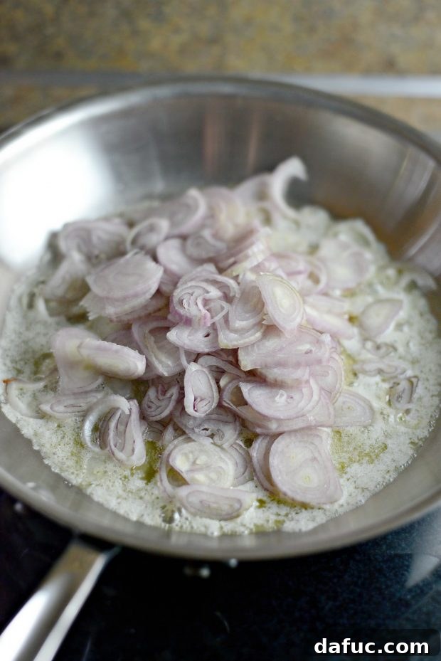 Sweet and Tangy Blue Cheese Shallot Dip 6 Shallots in a skillet, coated and stirring, ready for slow caramelization.