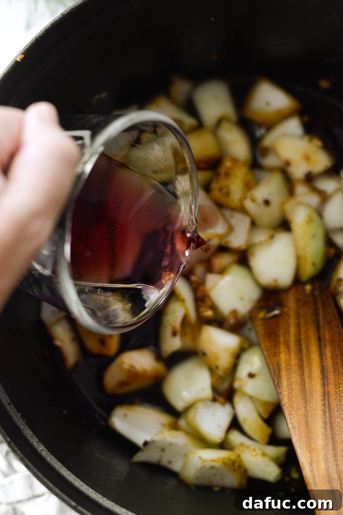 Deglazing the pot with red wine after cooking aromatics